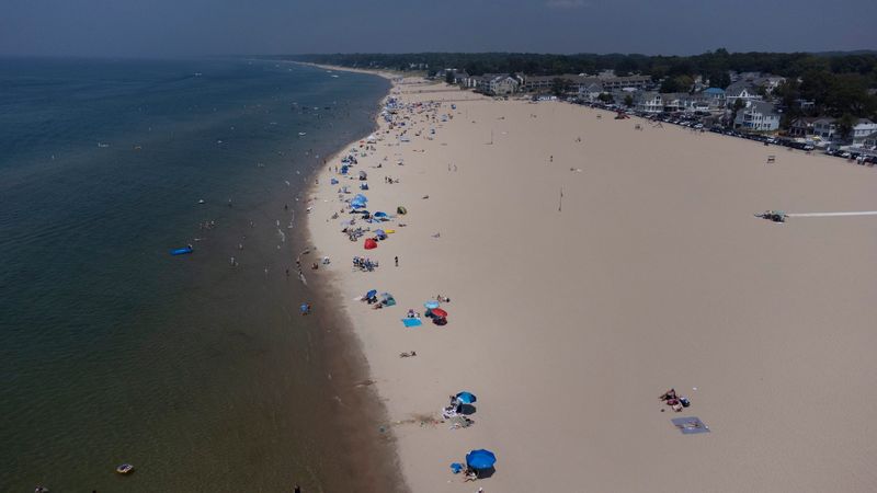 Beach goers in South Haven swim in Lake Michigan at their own risk on Tuesday, July 15, 2025. Lake Michigan is the deadliest lake in America, statistics show. Yet there are no lifeguards at 99% of Michigans public beaches.