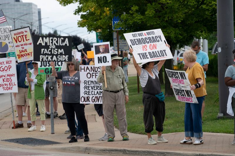 Protesters stand at Rochester Road and Big Beaver in Troy on Thursday, July 17, 2025 to participate in the Good Trouble protest action honoring the anniversary of the death of Congressman John Lewis.