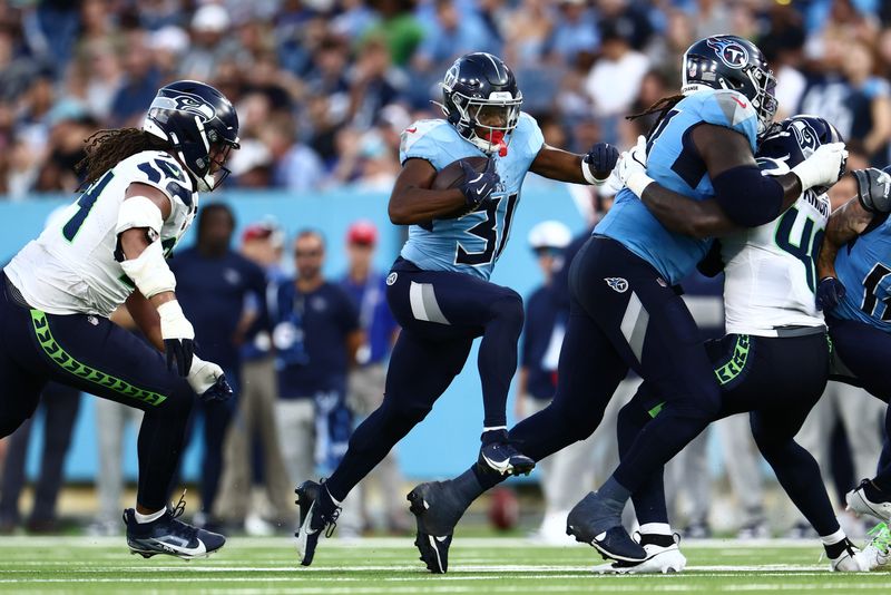 Aug 17, 2024; Nashville, Tennessee, USA; Tennessee Titans running back Jabari Small (31) runs the ball up the middle in the second quarter against the Seattle Seahawks at Nissan Stadium.