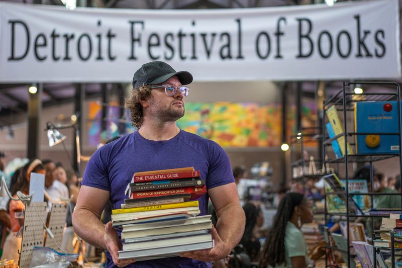 Dante Lamb stands for a photo during the Detroit Festival of Books at Eastern Market in Detroit on Sunday, July 20, 2025. Lamb said, “I go to the gym to give good hugs and lift heavy books.”