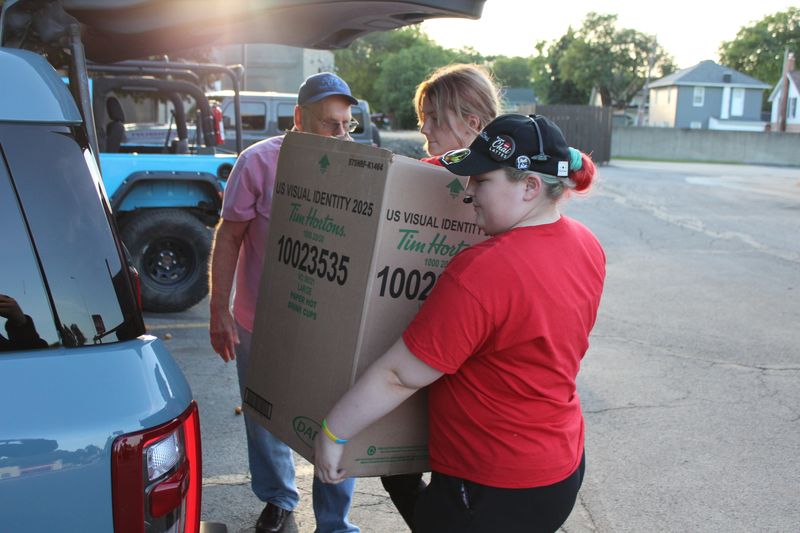 Employees from Tim Hortons, 404 S. Monroe St. in Monroe, place a box filled with confections in the back of Fred Fedorowicz's car.