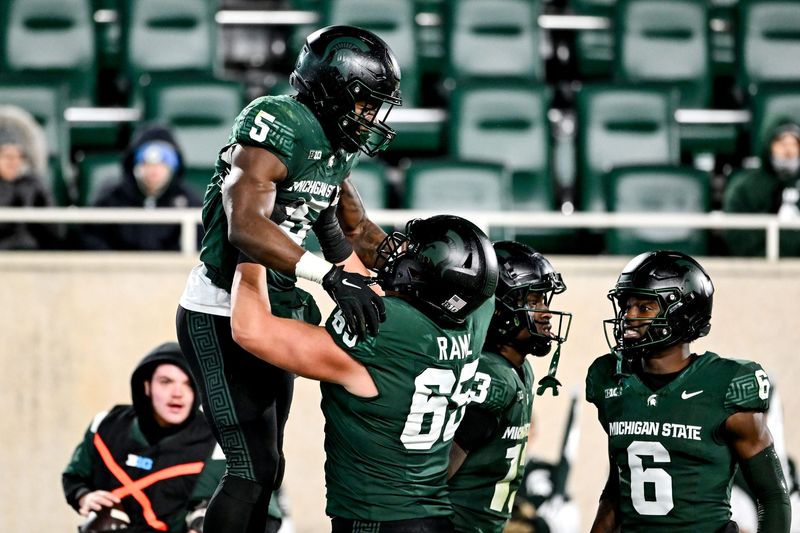 Michigan State's Nathan Carter, left, is hoisted I'm the air by teammate Stanton Ramil after Carter's second touchdown against Purdue during the second quarter on Friday, Nov. 22, 2024, at Spartan Stadium in East Lansing.