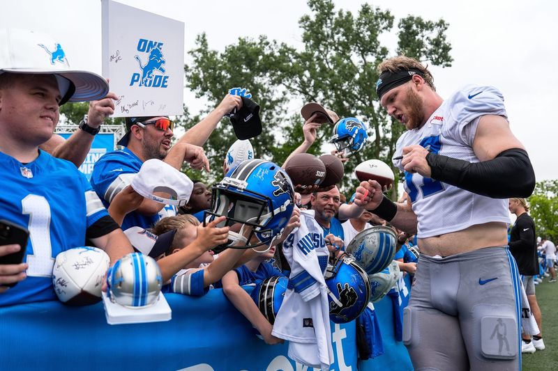 Detroit Lions defensive end Aidan Hutchinson (97) signs autographs for fans after practice during training camp at Meijer Performance Center in Allen Park on Saturday, July 26, 2025.