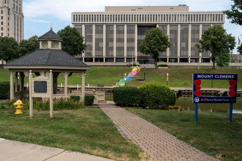 A walkway leads past a gazebo and a community pride sign in downtown Mount Clemens on Wednesday, July 16, 2025. The Macomb County Circuit Court building rises in the background along the Clinton River.