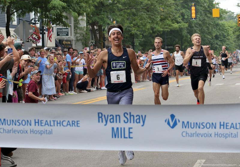 Adam Swanson of the Minnesota Distance Elite celebrates as he approaches the finish line during the running of the Ryan Shay Mile in downtown Charlevoix over the weekend. He ran a mile time of 3:55.1 to claim the victory.