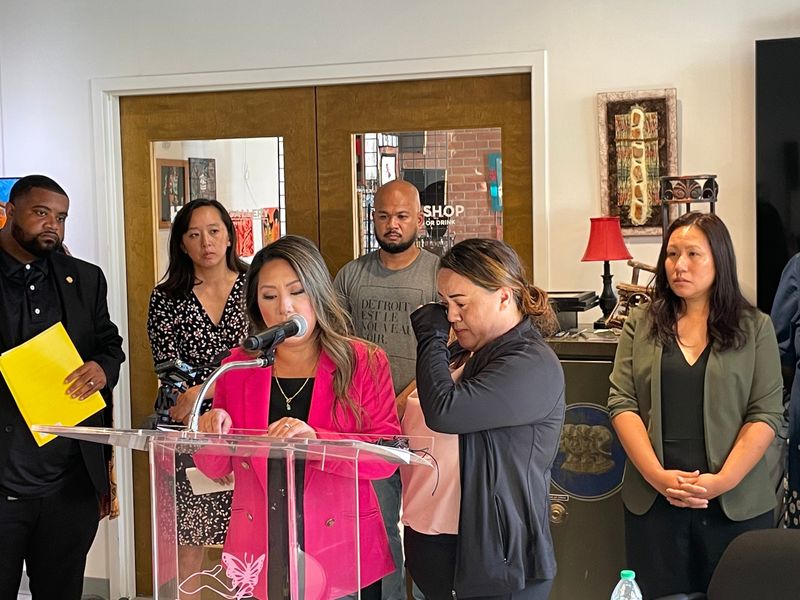 State Rep. Mai Xiong, D-Warren, reads on Aug. 8, 2025, a statement by Maiyia Xiong, of Pontiac, wife of Wa Kong Lor, a Hmong refugee detained by ICE on July 30, 2025. She wipes away tears as the legislator spoke. They and others spoke at a press conference in Detroit at the Hanan Center calling for the release of 16 Hmong and Laotian refugees detained by ICE in July 2025. Behind them are state Sen. Stephanie Chang, D-Detroit, and state Rep. Donovan McKinney, D-Detroit.