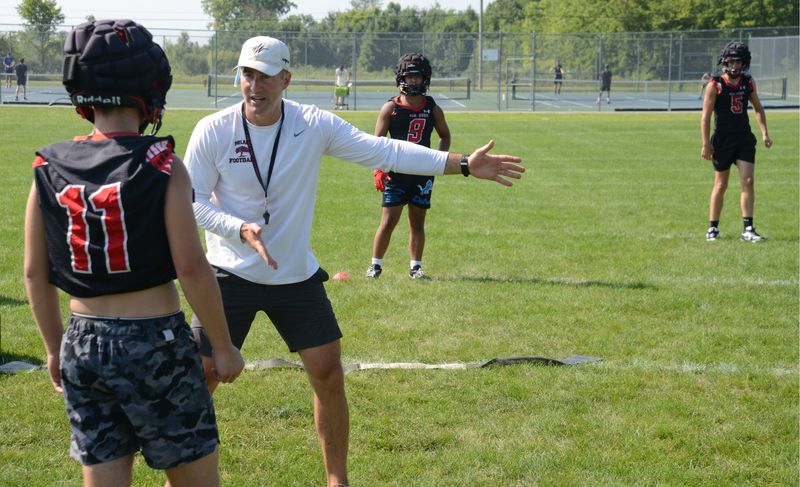 Milan football coach Jesse Hoskins gives instructions during the first practice of the season on Monday, Aug. 11, 2025.