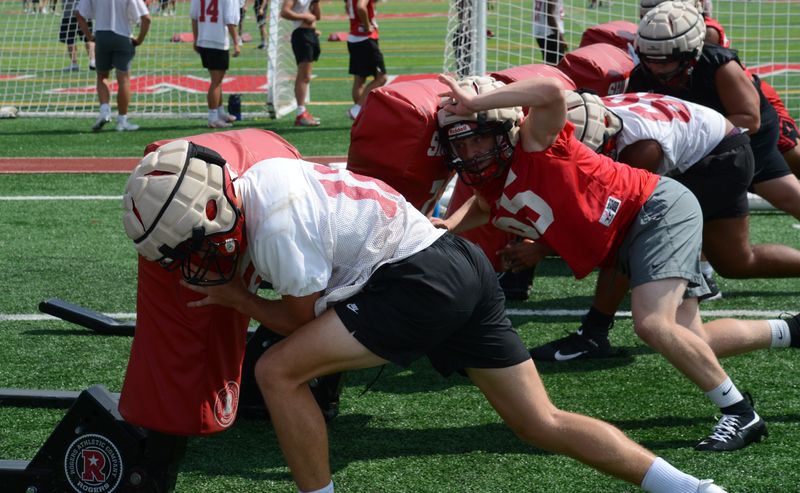 Brendon Bacon (left) and other Monroe players attack the blocking sled during the first football practice of the season on Monday, Aug. 11, 2025.