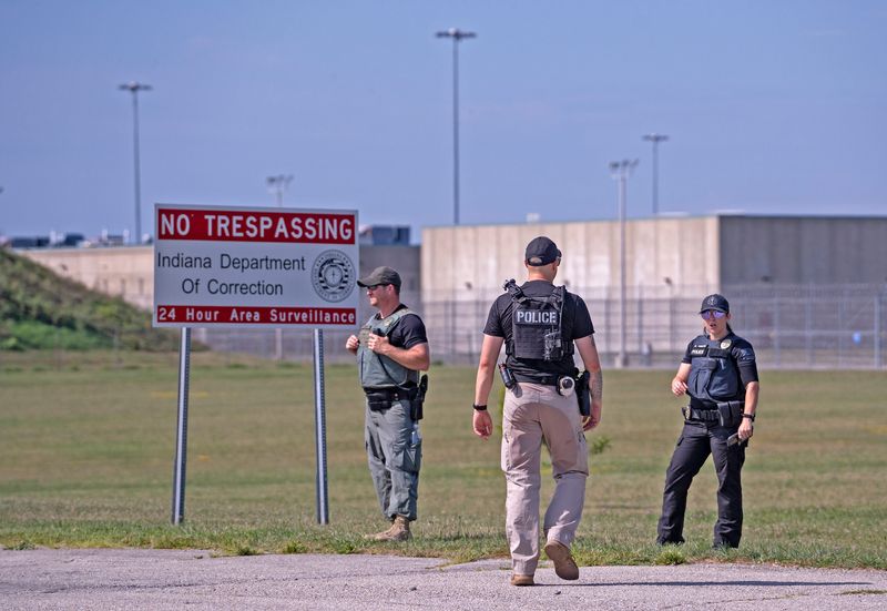 Police officers stand outside Miami Correctional Facility as a protest takes place about plans to use Miami Correctional as an ICE detention center. Photo taken Tuesday, Aug. 12, 2025.