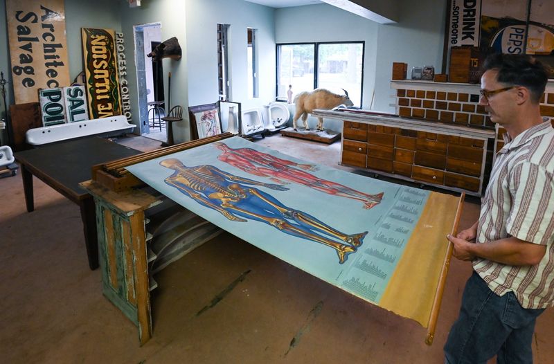 Dave Rademacher shows a vintage medical chart at his Good As Old Architectural Salvage shop in Grand Ledge.