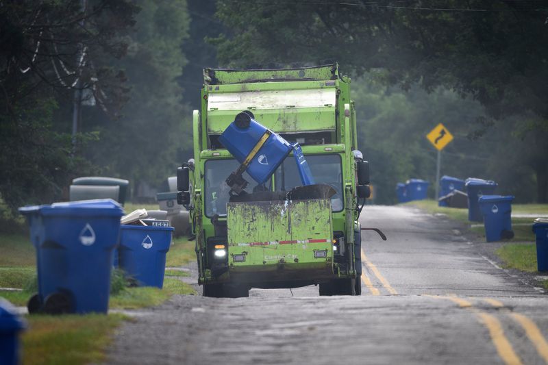 A Priority Waste truck picks up garbage on Midland Avenue in Waterford Township, Wed., August 13, 2025.