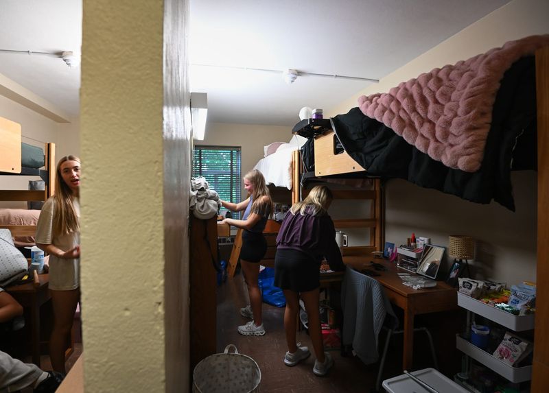 Grace Mitchell of East Lansing, second from right, and new roommate Kendall Ruster of Zeeland, set up their dorm suite, Tuesday, Aug. 19, 2025, at Akers Hall on the campus of Michigan State University. Also pictured is suite mate Macie VanAntwerp, left, of Okemos.