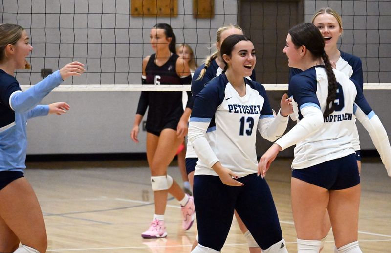 Petoskey senior Emma Mitas (far right) will have a larger role at the net this season, while working with fellow senior teammates Katie Parker (13) and Sarah Simonis (far left).