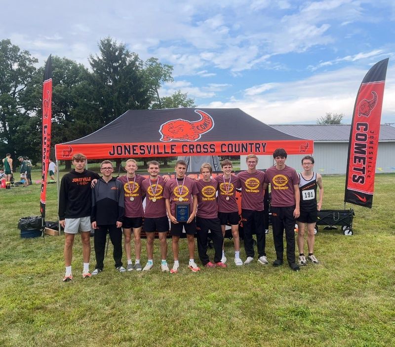 Jonesville boys cross country poses with the Webberville invite trophy.