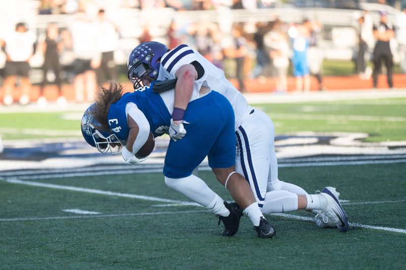 Lakeview senior Austin Wildermuth brings down Harper Creek senior Camari Hampton during the season-opening game at Harper Creek High School on Thursday, Aug. 28, 2025.