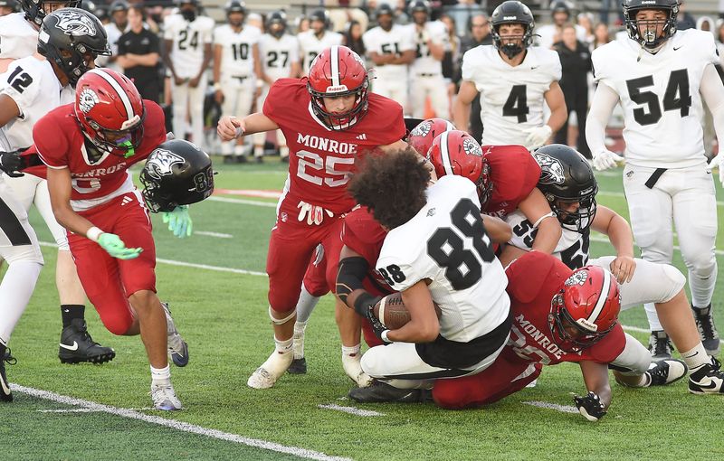 The Monroe defense hits the Plymouth player hard as his helmet flew off Thursday, August 28, 2025.