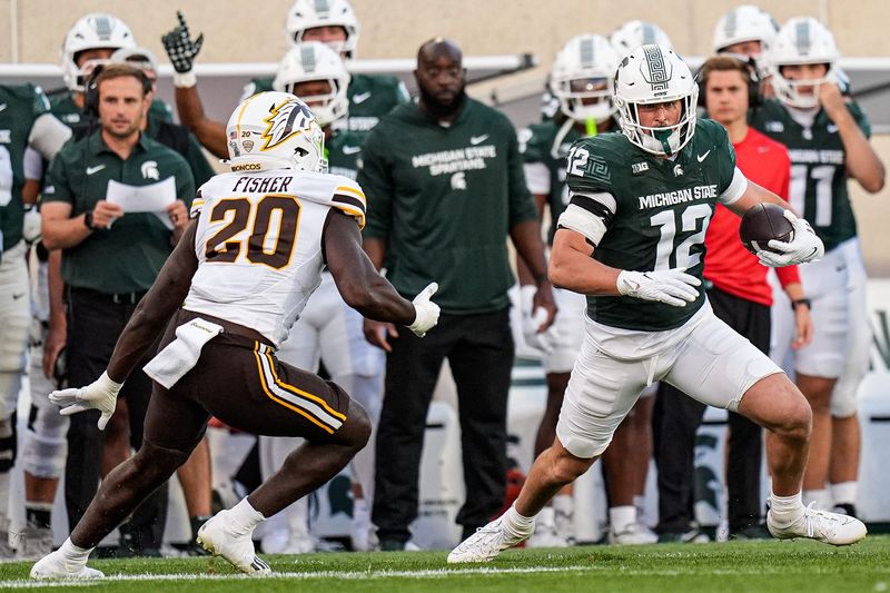Michigan State tight end Jack Velling (12) makes a catch against Western Michigan defensive end Kershawn Fisher (20) during the first half at Spartan Stadium in East Lansing on Friday, August 29, 2025.