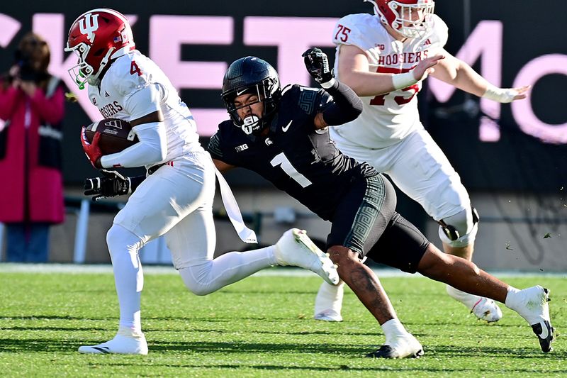 Nov 2, 2024; East Lansing, Michigan, USA; Indiana Hoosiers wide receiver Myles Price (4) runs away from Michigan State Spartans defensive back Nikai Martinez (1) during the second quarter at Spartan Stadium. Mandatory Credit: Dale Young-Imagn Images