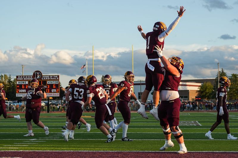 Davison senior quarterback Jaxson Dosh (1) celebrates a touchdown with Davison senior offensive lineman Ben Nichols (70) in the second quarter against Warren De La Salle Collegiate at Davison High School on Friday, September 5, 2025.