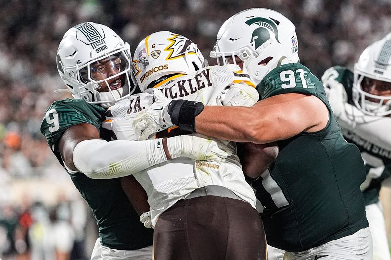 Michigan State defensive lineman Jalen Thompson (9), left, and defensive lineman Alex VanSumeren (91) tackle Western Michigan running back Jalen Buckley (6) for a safety during the second half at Spartan Stadium in East Lansing on Friday, August 29, 2025.