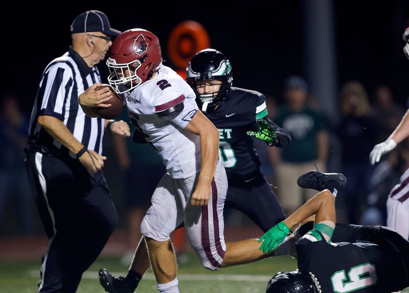 Portland's Kayden Dickerson, left, goes in for a touchdown against Olivet's Jack Masters, right, and Ethan Miars, Friday, Sept. 12, 2025, in Olivet.