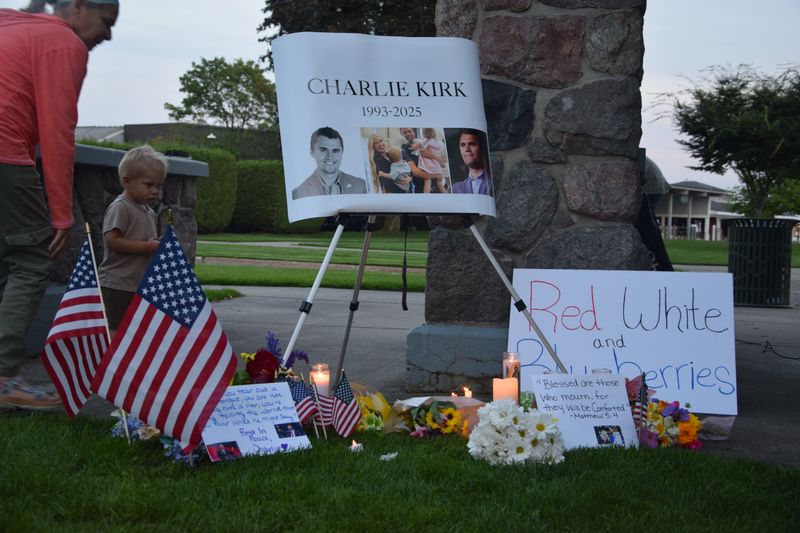 People brought flags, flowers, candles and signs in support of Charlie Kirk during a vigil on Wednesday, Sept. 17, 2025 in Harbor Springs.