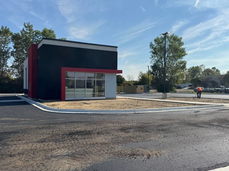 Contractors work to install a parking lot and driveway at Hillsdale's new KFC store Sept. 18.