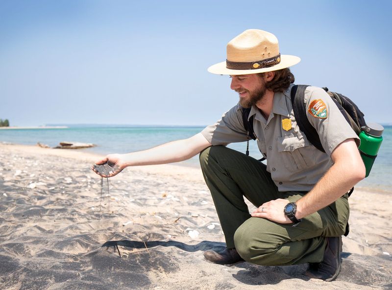 A National Park Service ranger at Sleeping Bear Dunes National Lakeshore shows magnetite-laden sand at the park's beach.