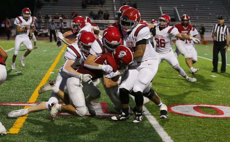 The Bedford defense gang tackles a ballcarrier during a 24-7 victory over Monroe on Friday, Sept. 19, 2025.