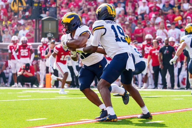 Michigan Wolverines quarterback Bryce Underwood hands the ball off to running back Justice Haynes for a touchdown against the Nebraska Cornhuskers during the second quarter at Memorial Stadium in Lincoln, Nebraska on Saturday, Sept. 20, 2025.