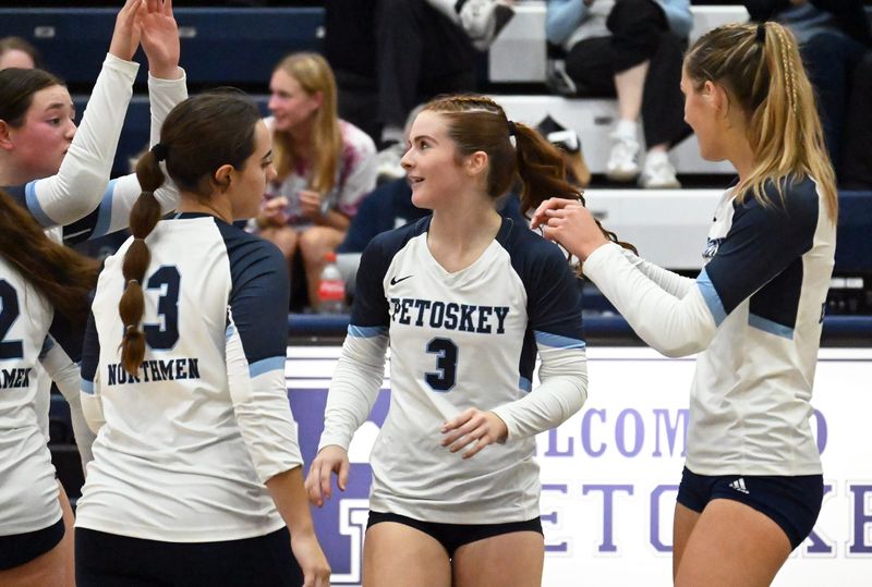 Teammates celebrate around Petoskey senior Alexis Cadarette (3) after a point earned during a Big North Conference match against Traverse City Central on Tuesday, Sept. 23.