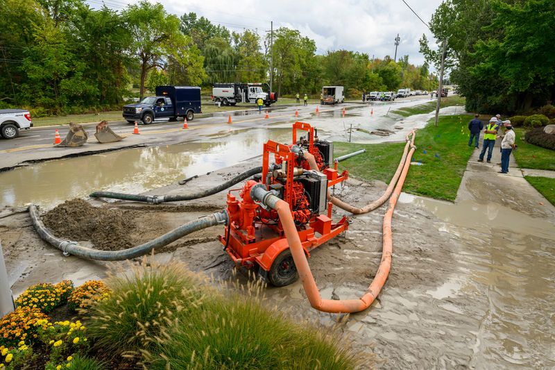 Crews work on draining the water resulting from a break in a 42-inch transmission main owned and operated by Great Lakes Water Authority on 14 Mile Road near Kingswood Blvd. In Novi, September 25, 2025.