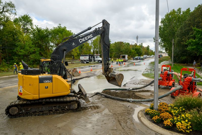 Crews work on draining the water resulting from a break in a 42-inch transmission main owned and operated by Great Lakes Water Authority on 14 Mile Road near Kingswood Blvd. In Novi, September 25, 2025.