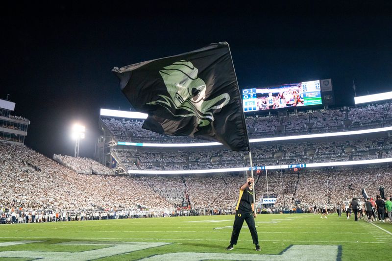 An Oregon cheerleader waves a Duck flag after a touchdown as the Oregon Ducks face the Penn State Nittany Lions on Sept. 27, 2025, at Beaver Stadium in University Park, Pennsylvania.