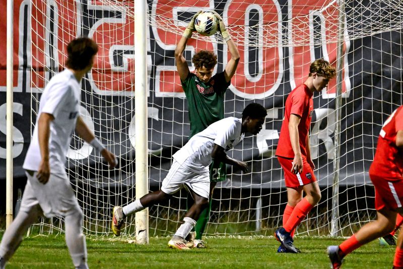 Mason's goalkeeper Landyn Loveless grabs a ball away from East Lansing's Edwen McAndrews during the second half on Tuesday, Sept. 30, 2025, at Mason High School.