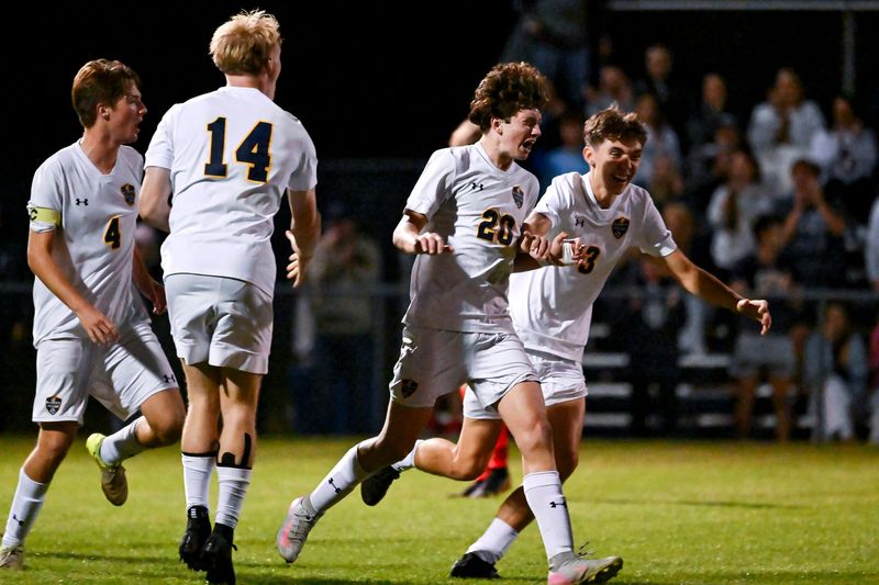 DeWitt's Mason Raborn, center, celebrates after his kick went between Mason's goalkeeper's legs for a score during the second half on Thursday, Oct. 2, 2025, in the CAAC Gold Cup final at Mason High School.