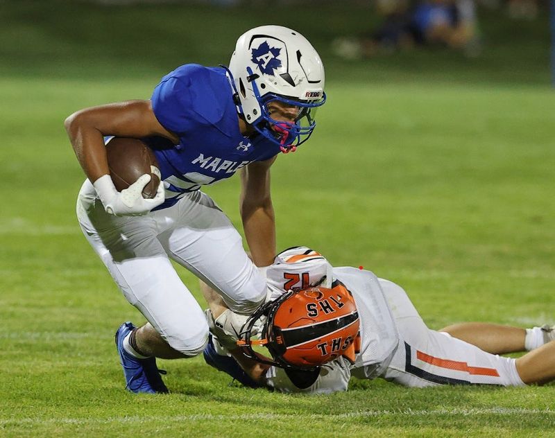 Adrian ball carrier Jamari Blue (25) is brought down by a Tecumseh defender on Friday
