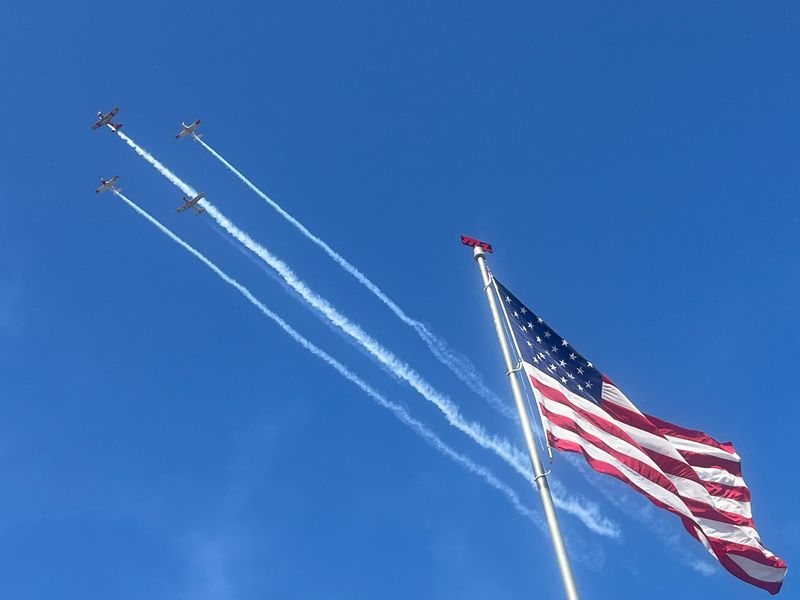 Military planes flying over releasing colored smoke above the American flag at M1 Concourse on October 4th in Pontiac, Michigan