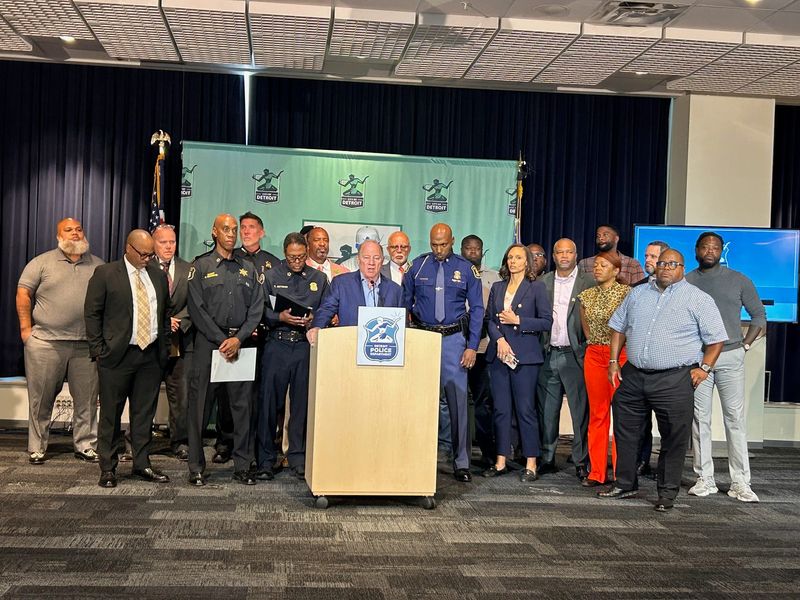 Detroit Mayor Mike Duggan speaks about the city's declining crime rate so far in 2025 at the public safety building downtown on Oct. 6, 2025, surrounded by about two dozen local, state and federal law enforcement officials; court members, and community leaders.
