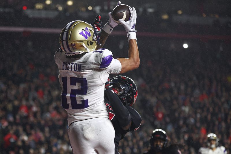 Sep 27, 2024; Piscataway, New Jersey, USA; Washington Huskies wide receiver Denzel Boston (12) catches the ball a touchdown pass during the second half against Rutgers Scarlet Knights defensive back Robert Longerbeam (7) at SHI Stadium. Mandatory Credit: Vincent Carchietta-Imagn Images