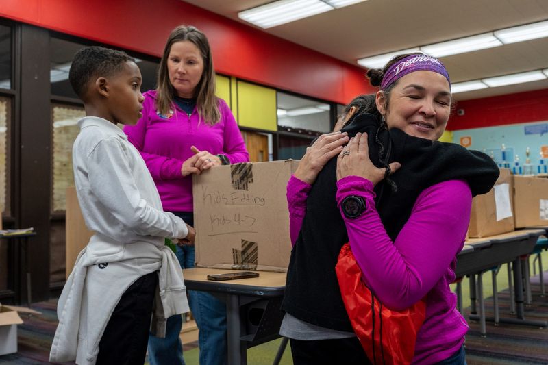 Toni Reese, co-owner of Running Lab, hugs a student during the Detroit Free Press Marathon Presented by Priority Health, shoe distribution day at Bates Academy in Detroit on Wednesday, Oct. 8, 2025.