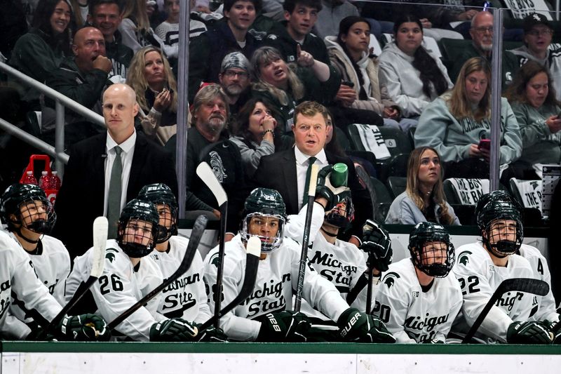 Michigan State's head coach Adam Nightingale, center, looks on from the bench during the first period in the game against New Hampshire on Thursday, Oct. 9, 2025, at Munn Ice Arena in East Lansing.