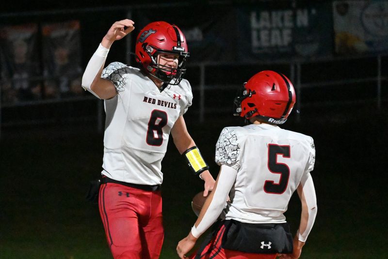 East Jordan quarterback William Webb (8) celebrates a touchdown scored against Harbor Springs with teammate Wyatt Pinney on Friday, Oct. 10 in Harbor Springs.