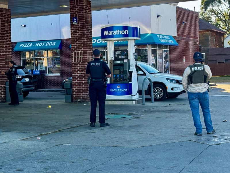 Officers stand near the pumps of the Marathon gas station on Military Street in Port Huron while investigating a shooting in October.