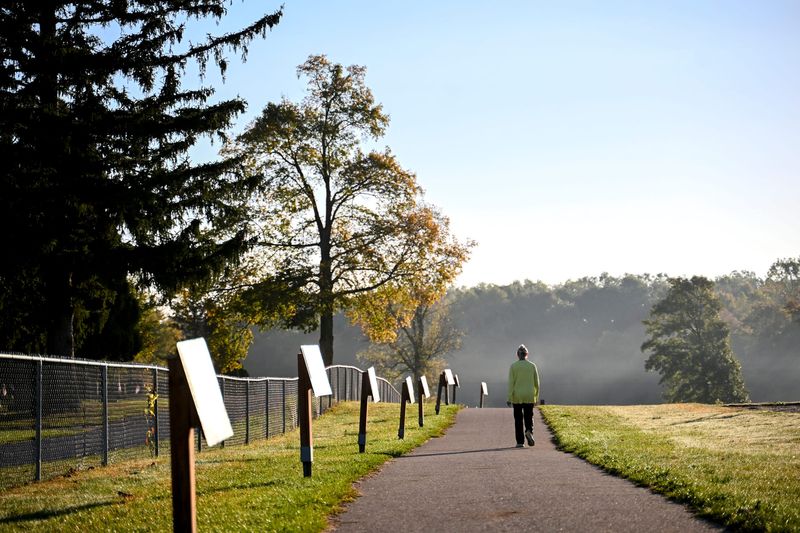 A patron walks around the paved path at Simmons Memorial Park on Tuesday, Oct. 14, 2025, in Webberville.