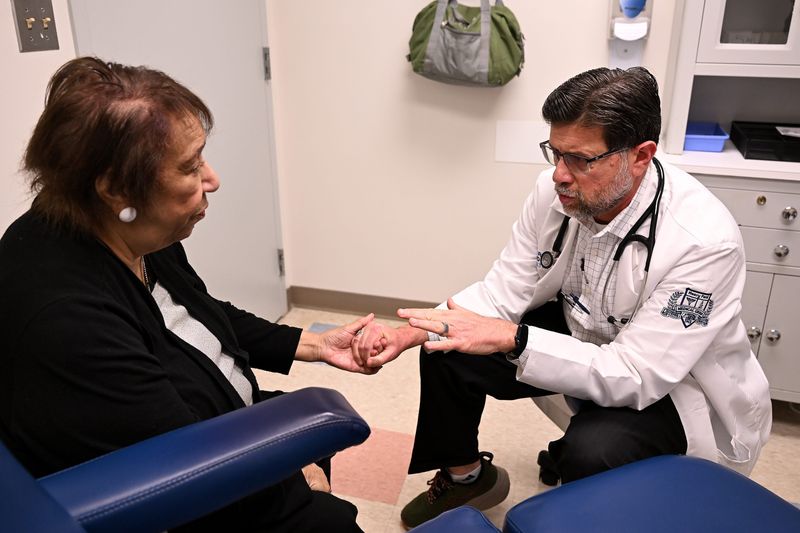 Dr. Mirza Beg, division head of geriatrics at Henry Ford Health, talks with Althea Anderson, 84, about medications and other topics near the end of their appointment at Henry Ford Medical Center - Livonia in October. Providers like Beg are in high demand as Michigan's population ages.