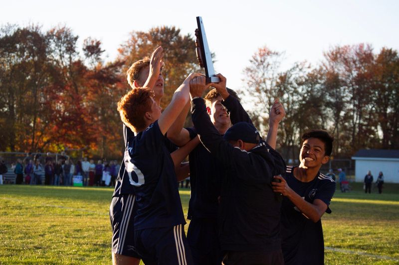 Coach Neal Brady delivers the trophy to his players.