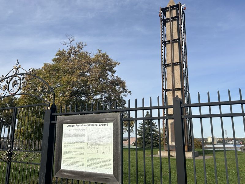 A large stone obelisk has been covered in a cage to prepare for its removal at Brady Park in Sault Ste. Marie, the site of ancient burial grounds.