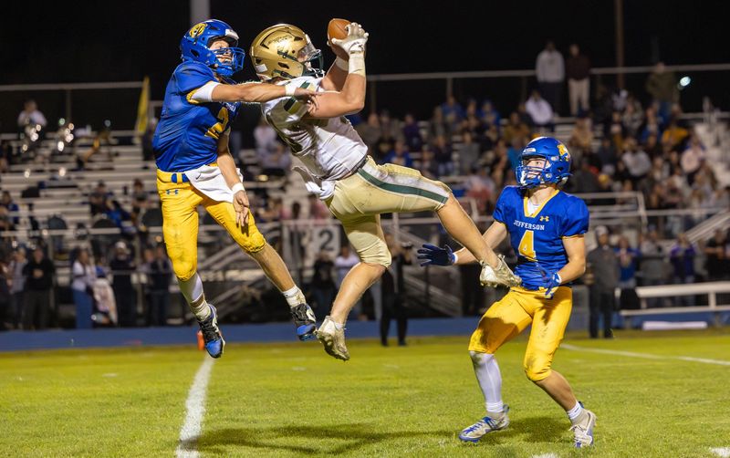 St. Mary Catholic Central's Brock Cousino makes a leaping catch against Luke Beaudrie of Jefferson during a 20-15 SMCC win on Friday, Oct. 17, 2025.