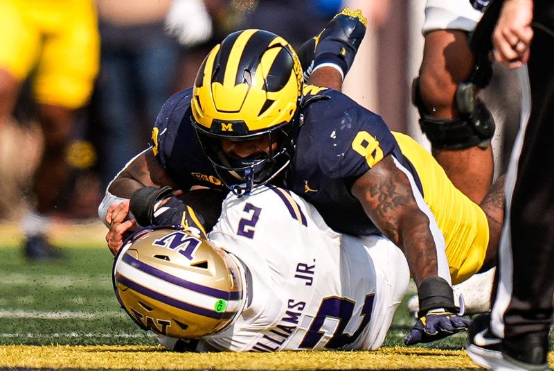 Michigan edge Derrick Moore (8) sacks Washington quarterback Demond Williams Jr. (2) during the first half at Michigan Stadium in Ann Arbor on Saturday, Oct. 18, 2025.